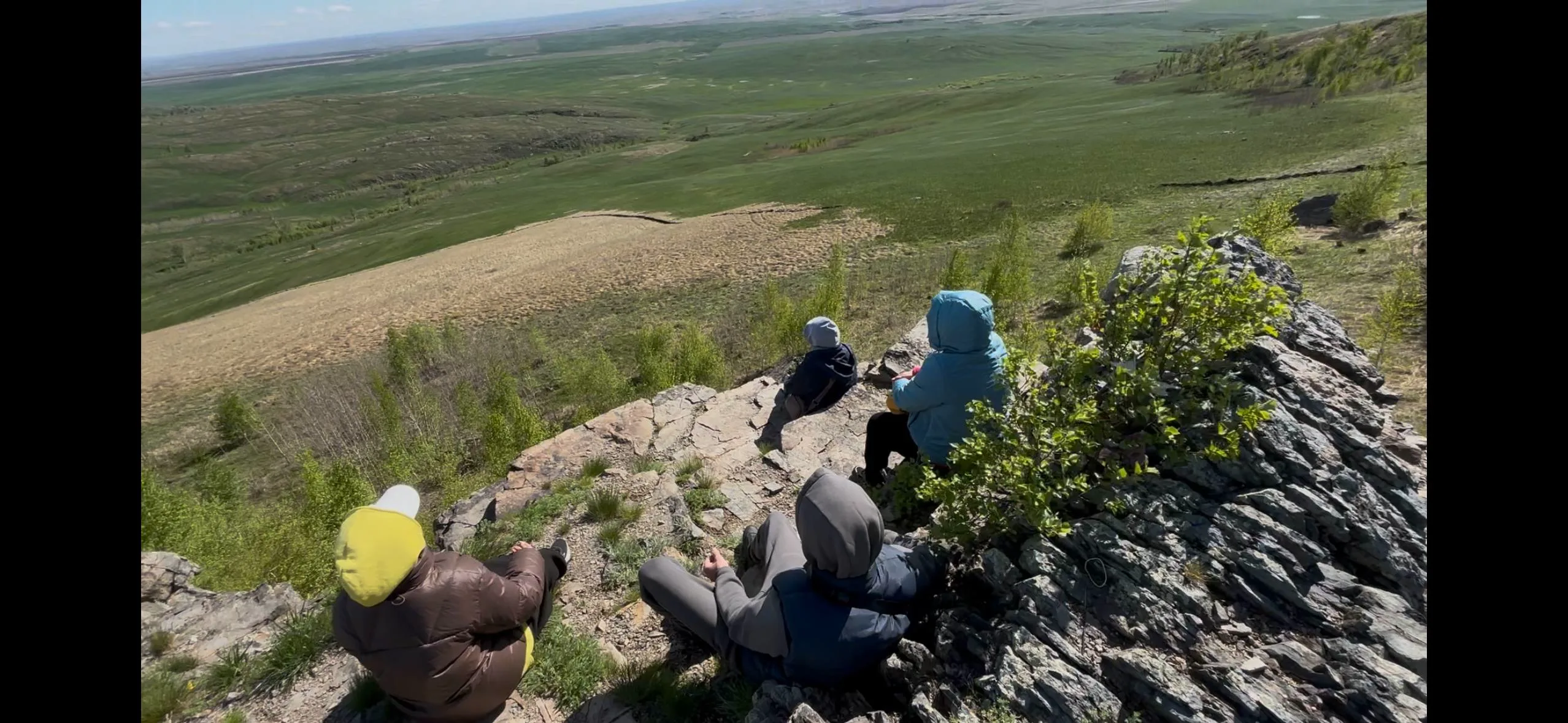 Люди сидят на природных каменных скамьях на обрыве Чеки
